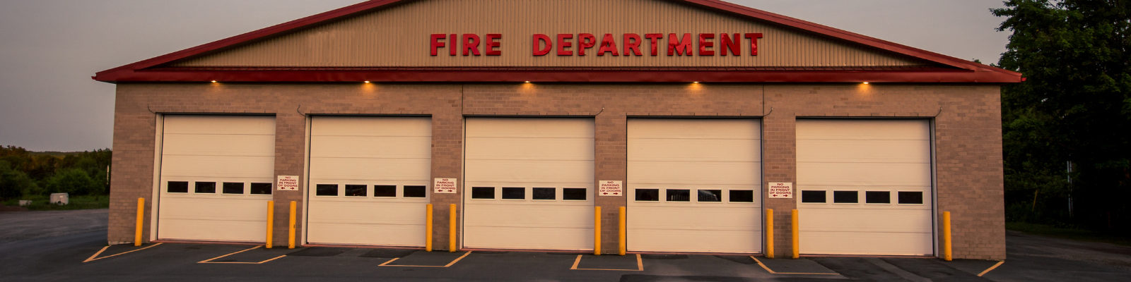 The outside of a fire department, featuring several doors.